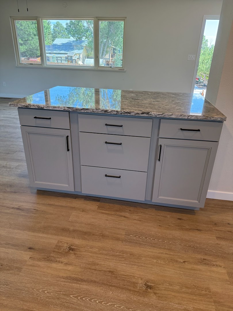 Finished gray kitchen island cabinetry and stone countertop